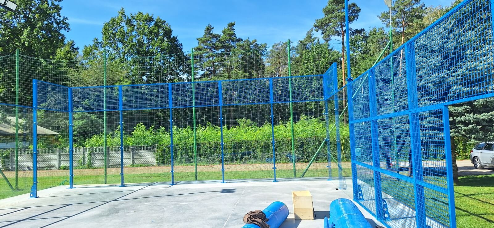 Konstrukcja kortu do padla od narożnika — siatka stalowa i szklane ściany